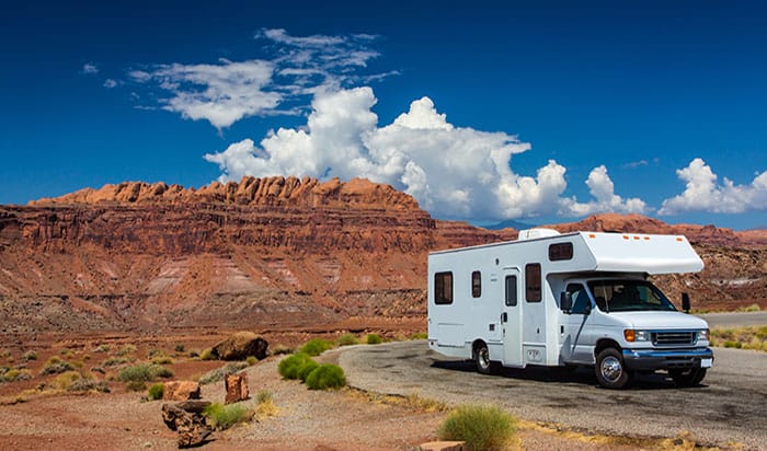 RV canyonlands white RV / campervan in canyonlands USA with red cliffs and blue sky behind it