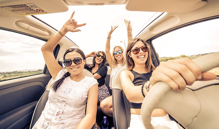 four girls driving in a convertible car and having fun four girls driving in a convertible car and having fun